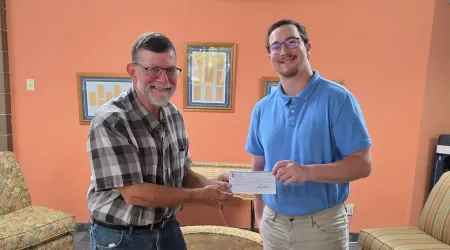 AAACU Team member presents a check to a member of the Cheboygan High School Senior Class of 2025